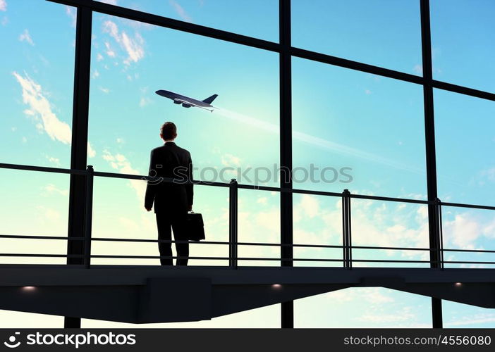 Businessman at airport. Image of businessman at airport looking at airplane taking off