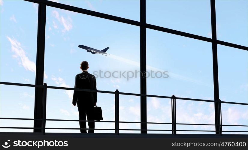 Businessman at airport. Image of businessman at airport looking at airplane taking off