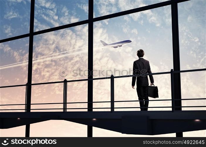 Businessman at airport. Image of businessman at airport looking at airplane taking off