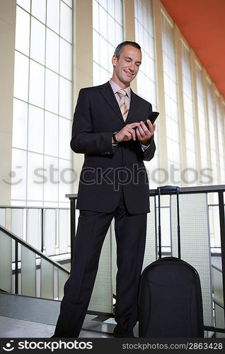 Businessman at Airport Using Cell Phone