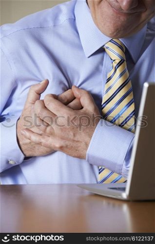 Businessman At Computer Suffering Heart Attack