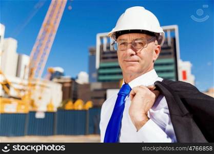 Businessman at construction site. Businesman wearing safety helmet at construction site