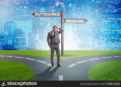 Businessman at crossroads deciding between outsourcing and inhouse. Businessman at crossroads deciding between outsourcing and inhou