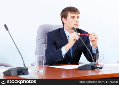 Businessman at meeting. Image of young businessman sitting at table at business meeting