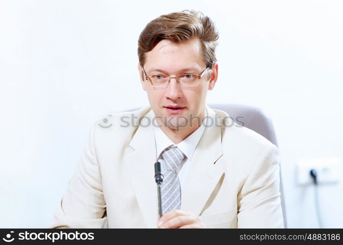 Businessman at meeting. Image of young businessman sitting at table at business meeting