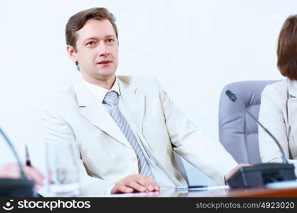 Businessman at meeting. Image of young businessman sitting at table at business meeting