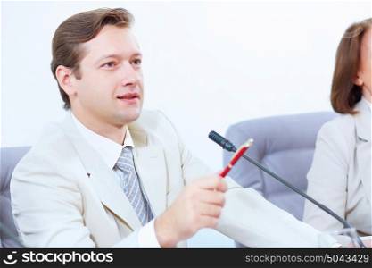Businessman at meeting. Image of young businessman sitting at table at business meeting