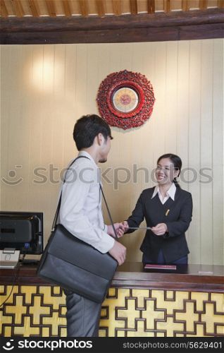 Businessman at Reception Desk of Hotel