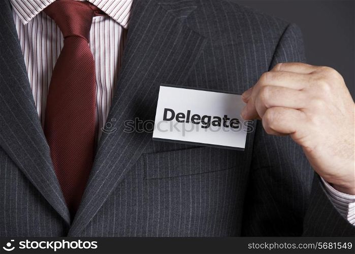 Businessman Attaching Delegate Badge To Jacket