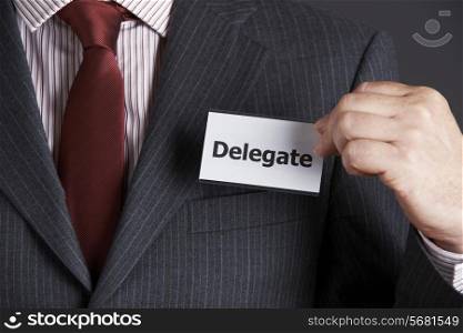 Businessman Attaching Delegate Badge To Jacket