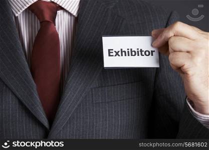 Businessman Attaching Exhibitor Badge To Jacket