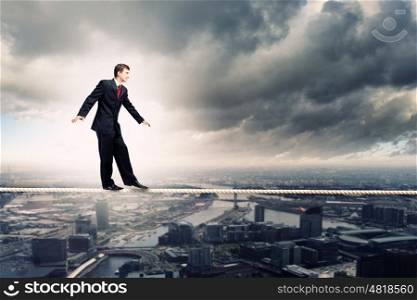 Businessman balancing on rope. Image of pretty businessman balancing on rope