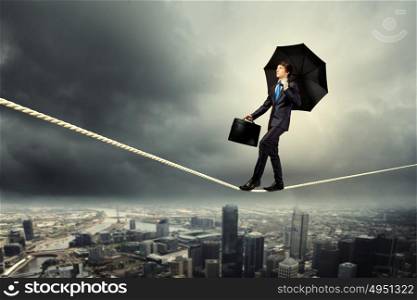 Businessman balancing on rope. Image of pretty businessman balancing on rope