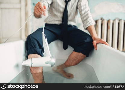 Businessman bankrupt with hairdryer in bathtub, suicide man concept. Problem in business, stress. Businessman with hairdryer in bathtub, suicide man