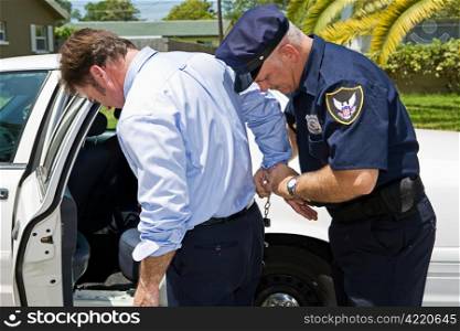 Businessman being handcuffed and placed under arrest.