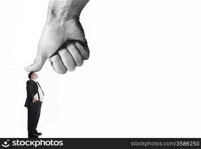 Businessman being pressed by thumb of giant hand, digital composite, colour enhanced, side view