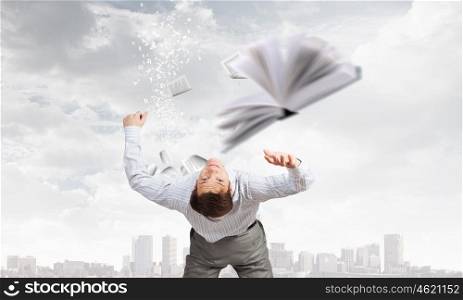 Businessman bent over and evading from book. Man evading flying book