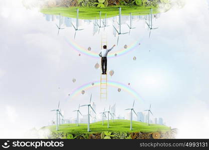 Businessman between two worlds. Businessman standing on ladder between two ecological energy realities