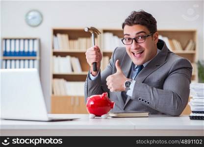 Businessman breaking piggybank in the office
