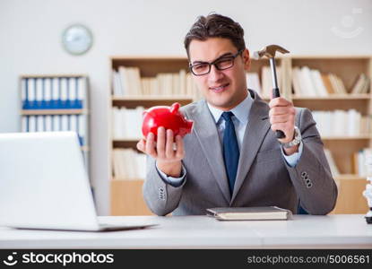 Businessman breaking piggybank in the office