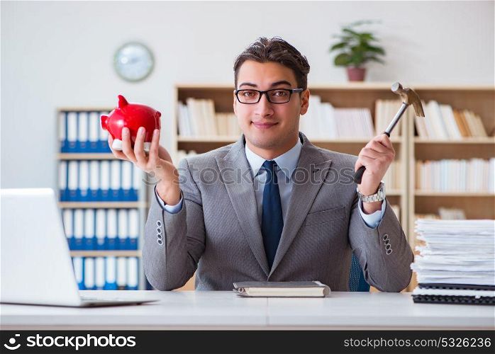 Businessman breaking piggybank in the office