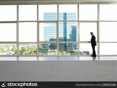 Businessman by window in office building