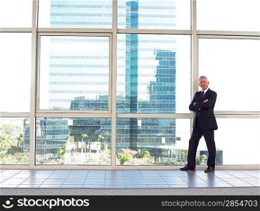 Businessman by window in office building portrait