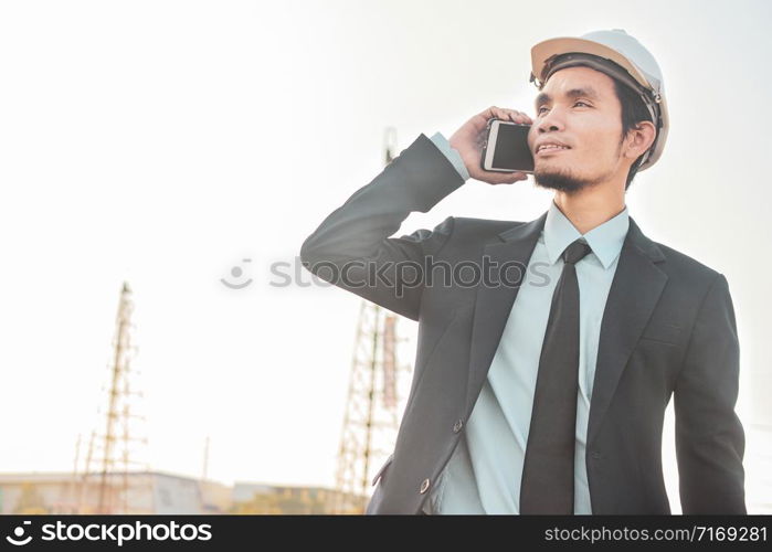 Businessman call cell phone or mobile smart phone at the construction site