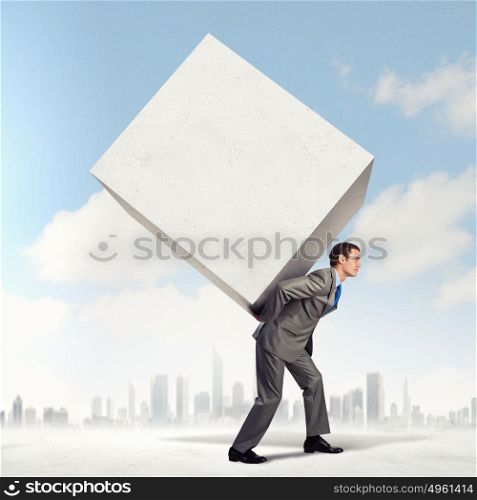 Businessman carrying cube. Image of businessman carrying big white cube on his back