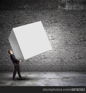 Businessman carrying cube. Young businessman carrying white big cube. Place for text