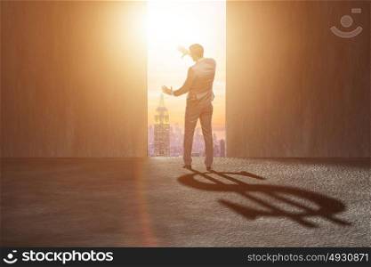 Businessman casting dollar shape shadow in business concept