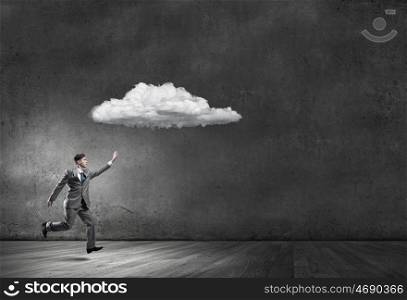 Businessman catch cloud. Young businessman running and trying to catch cloud