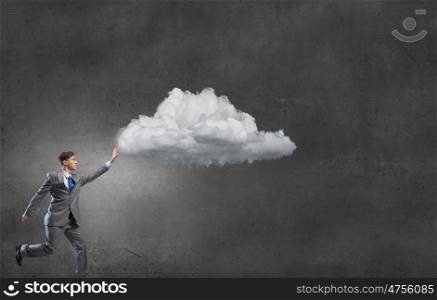 Businessman catch cloud. Young businessman running and trying to catch cloud