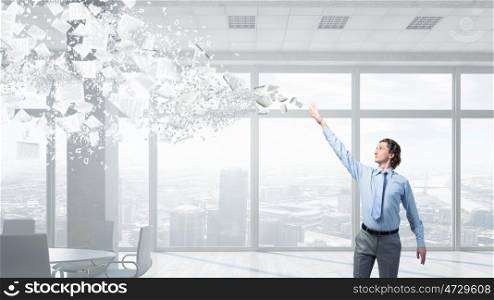 Businessman catching flying papers. Businessman controlling paper documents flying in air