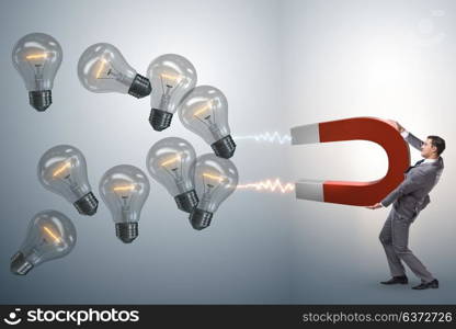 Businessman catching light bulbs on horseshoe magnet