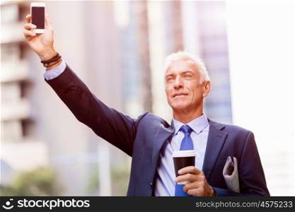 Businessman catching taxi in city. Businessman in suit catching taxi in city with cup of coffee in his hands