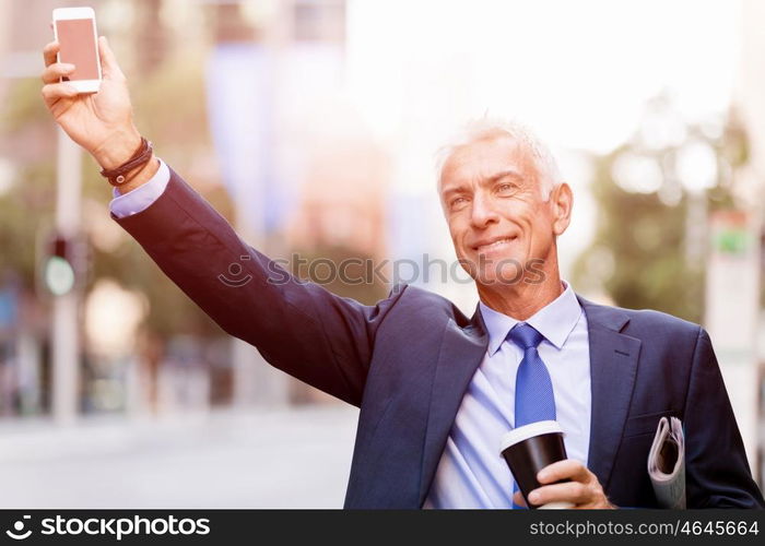 Businessman catching taxi in city. Businessman in suit catching taxi in city with cup of coffee in his hands