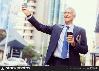 Businessman catching taxi in city. Businessman in suit catching taxi in city with cup of coffee in his hands