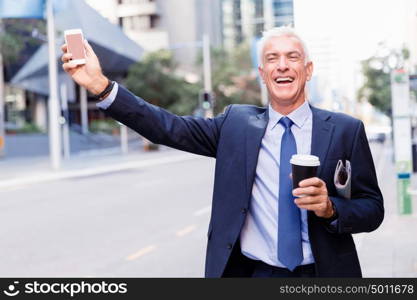 Businessman catching taxi in city. Businessman in suit catching taxi in city with cup of coffee in his hands