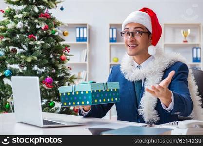 Businessman celebrating christmas holiday in the office. The businessman celebrating christmas holiday in the office