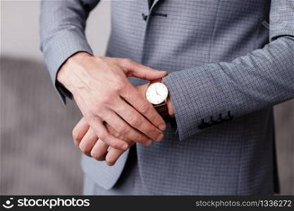 businessman checking time on his wrist watch, man putting clock on hand,groom getting ready in the morning before wedding ceremony. man puts on a watch. selective focus