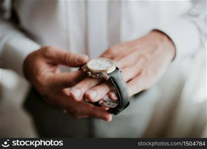 businessman checking time on his wrist watch, man putting clock on hand,groom getting ready in the morning before wedding ceremony.. businessman checking time on his wrist watch, man putting clock on hand,groom getting ready in the morning before wedding ceremony
