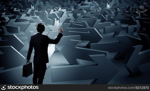 Businessman choosing his business direction. Confused young businessman in labyrinth choosing right way