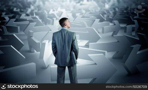 Businessman choosing his business direction. Confused young businessman in labyrinth choosing right way