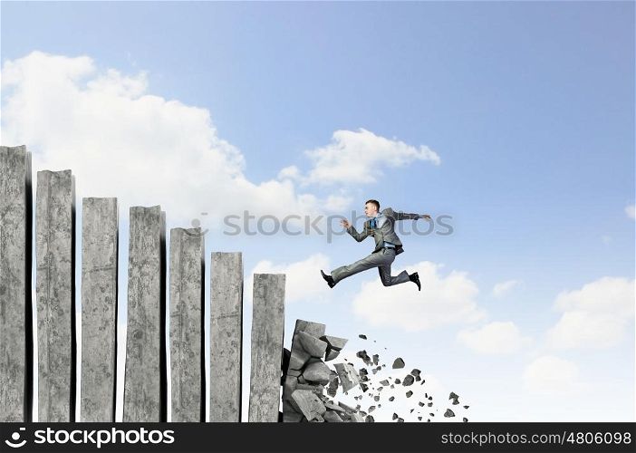 Businessman climbing stone ladder . Young businessman walking up collapsing staircase representing success concept