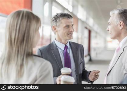 Businessman communicating with colleagues on railroad platform