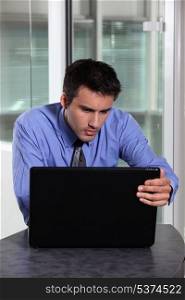 Businessman concentrating fully on laptop screen