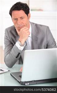 Businessman confused by his laptop