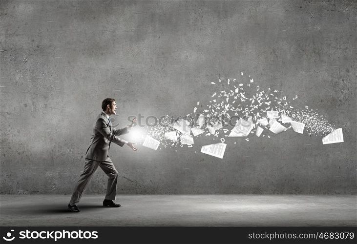 Businessman controlling paper documents flying in air. Everything is under control
