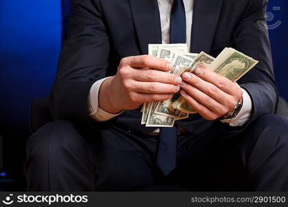 Businessman counts money in hands.